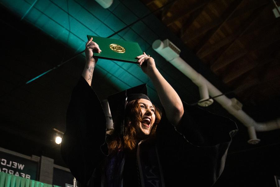 周六，<a href='http://dwelqz.eagle1027.com'>澳门网上博彩官方网站</a>的一名毕业生在毕业典礼上展示她的毕业证书.